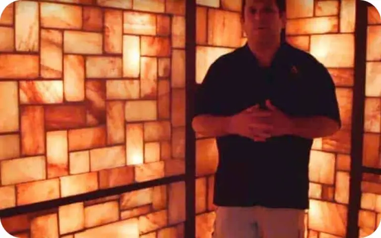 Man standing in front of a custom salt wall installation with himalayan salt bricks