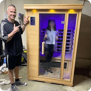 Happy man in front of his sauna with his daughter inside