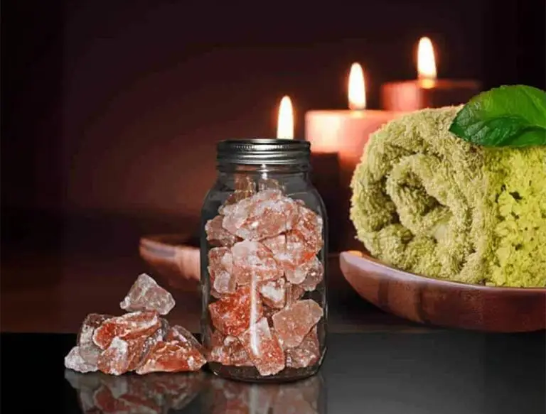 Himalayan salts with a towel and candles in the background in a relaxing setup