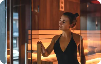 Lady looking relaxed and happy next to a sauna